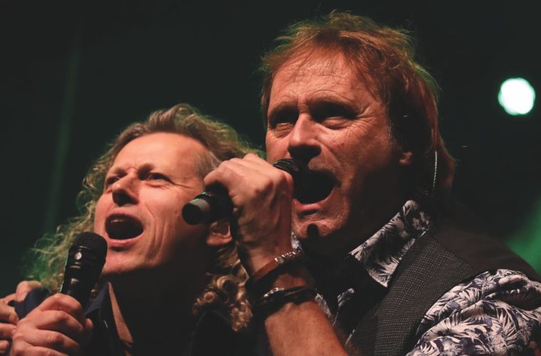 Twee muzikanten voeren Simon & Garfunkel-klassiekers uit met een vierkoppige band op het podium van Theater De Speeldoos in Baarn.